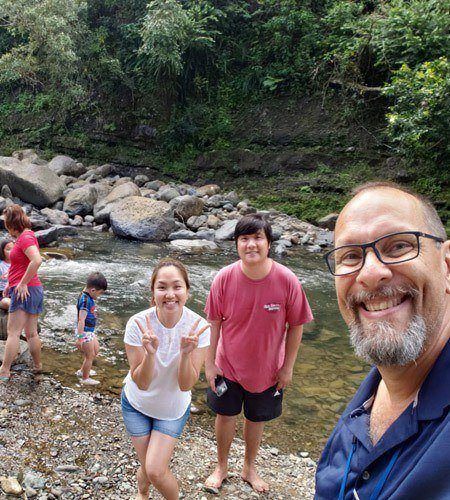 A small group of hikers at the falls with tour guide